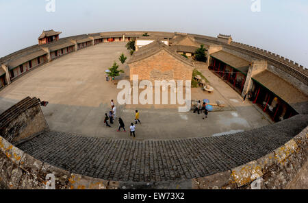 Dali, China's Shaanxi Province. 17th June, 2015. Tourists visit the Fengtu Charitable Granary in Dali County, northwest China's Shaanxi Province, June 17, 2015. Fengtu Charitary Granary, which is 17 kilometers away from Dali County, is still used to store grain even though it has more than 100 years of history. The intact granary, which was built in 1885, is a circular town in which 58 caves each is able to store 90 tons of grain. It was famous for the title 'The No. 1 Granary' named by Empress Dowager Cixi (1835-1908). © Tao Ming/Xinhua/Alamy Live News Stock Photo