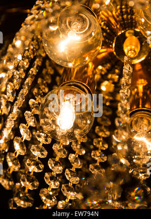 detail of a crystal chandelier with golden light Stock Photo