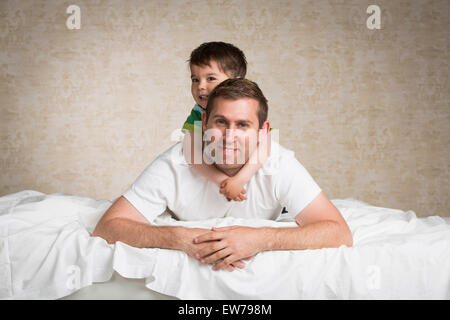 Father and son lying on a bed Stock Photo