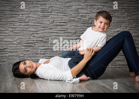 Mother and son cuddling on the floor Stock Photo