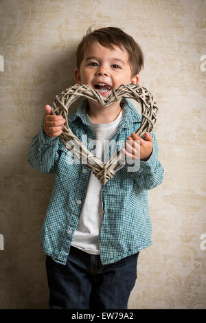 Little boy holding a wooden heart in his hand Stock Photo