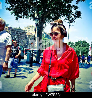 Woman in red walking down Passeig de Gracia. Barcelona, Catalonia, Spain. Stock Photo