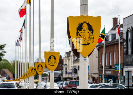 The image of William Shakespeare writing a play appears on shields on flag poles in his home town of Stratford upon Avon, UK Stock Photo