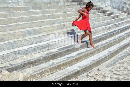 Girl in a red dress running down steps Stock Photo