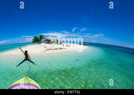 Teenage boy jumping off the front of a boat into the sea, Semporna, Sabah, Malaysia Stock Photo