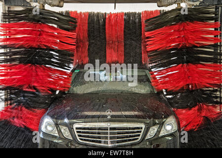 A Vehicle of the Mercedes-Benz brand is cleaned in a Gantry car wash. Stock Photo