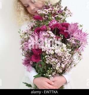 Girl holding large bunch of pink flowers Stock Photo