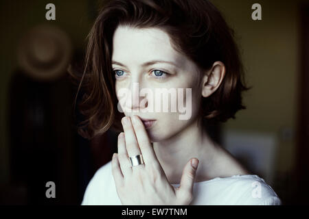Portrait of a woman holding her hand to her mouth Stock Photo