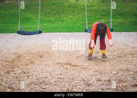 Boy hanging on a swing in a playground Stock Photo