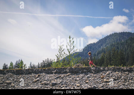 Side view of a boy walking by a stream Stock Photo