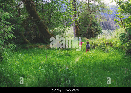 Three children running through tall grass Stock Photo