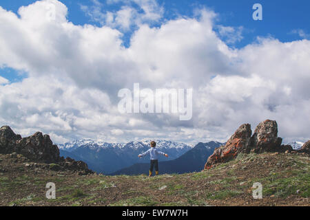 Boy standing on a mountain with his arms outstretched, USA Stock Photo