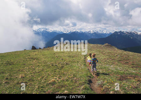 Two children running down a path on a mountain Stock Photo