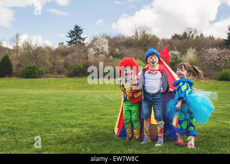 Three smiling children dressed as clowns Stock Photo