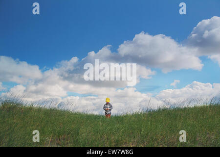 Boy in a yellow hat standing outdoors Stock Photo