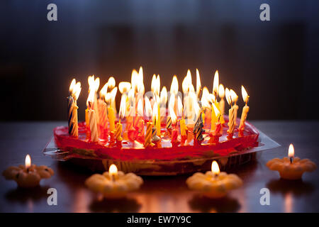 Strawberry cake with lots of candles on a table Stock Photo