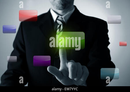 Business man pushing a green button on a touchscreen Stock Photo