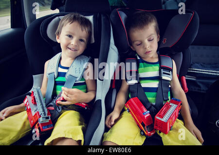 Two sweet boys, sleeping in the car with teddy bears after a long journey Stock Photo