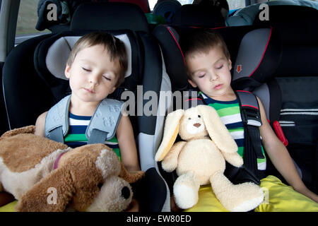 Two sweet boys, sleeping in the car with teddy bears after a long journey Stock Photo