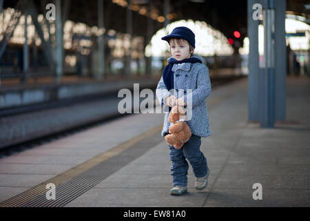 Little boy with his teddy bear on the mail railway station in Prague Stock Photo