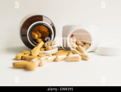 Vitamin and herb capsule spilling out of a bottle Stock Photo