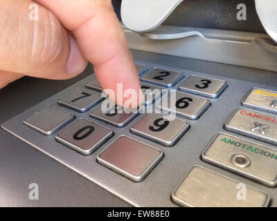Man finger pressing password number on ATM machine Stock Photo