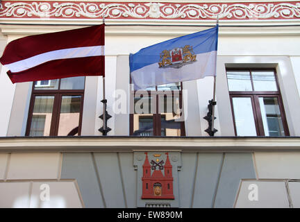 Flags flying and the Coat of Arms on an apartment building in Riga Stock Photo