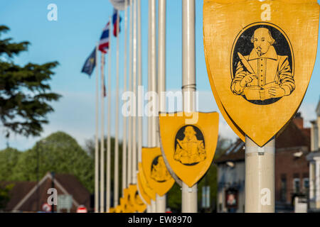 The image of William Shakespeare writing a play appears on shields on flag poles in his home town of Stratford upon Avon, UK Stock Photo
