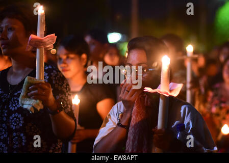 Women pilgrims bring lit candles as they are marching during a procession to commemorate Good Friday in Larantuka, East Nusa Tenggara, Indonesia. Stock Photo