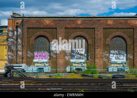 Graffiti on an old railway depot on the approach to Victoria station in London Stock Photo