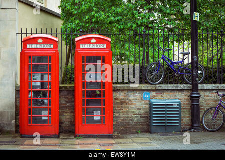 Twin red British telephone boxes and bikes in the background Stock Photo