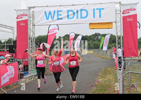 Mother and two daughters pass the finishing line at 'Race for LIfe' women-only charity fundraising running event for Cancer Research UK. 20th June, 2015. Kempton Park racecourse, Staines Road East, Sunbury on Thames, Middlesex, England, Great Britain, United Kingdom, UK, Europe. Credit:  Ian Bottle / Alamy Live News Stock Photo