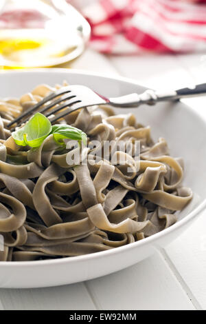 cooked black tagliatelle pasta on plate Stock Photo