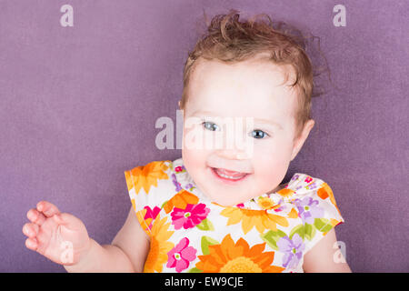 Beautiful laughing baby girl in a floral dress Stock Photo