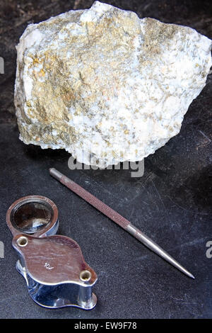 Mining exploration concept with mineral ore and magnifier Stock Photo