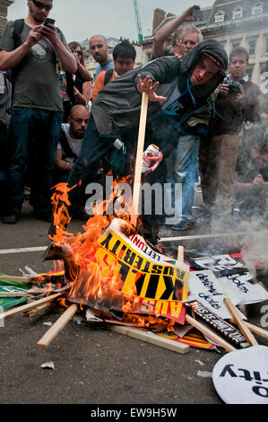 Police putting out fire of burning placards in Parliament Square during Anti-austerity march central London June 20th 2014 Stock Photo