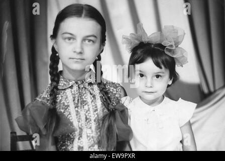 Studio portrait of two sisters. USSR, ca. 1985. Stock Photo