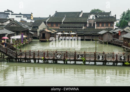Flat wooden bridge crossing the canal surrounded by traditional Chinese houses in the historic scenic Wuzhen water town, China Stock Photo