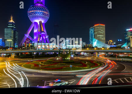 Light trails at night at roundabout with The Oriental Pearl TV Tower in the background, Shanghai, China Stock Photo
