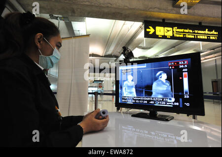 Bangkok, Thailand. 21st June, 2015. An officer looks at a thermoscan checking people's body temperature at Suvarnabhumi Airport in Bangkok, Thailand, June 21, 2015. Thailand's public health ministry on Thursday confirmed the country's first case of the Middle East Respiratory Syndrome (MERS). Citizens and travellers have begun to undertake preventive methods such as wearing protective facial masks in Bangkok. © Rachen Sageamsak/Xinhua/Alamy Live News Stock Photo