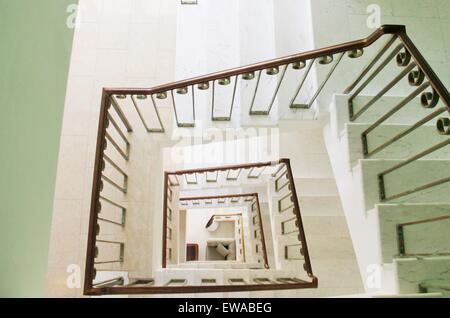 Spiral square stairs viewed from above ariel view- height, long, shapes, stairwell, light, upstairs, black, concrete, steps, geo Stock Photo