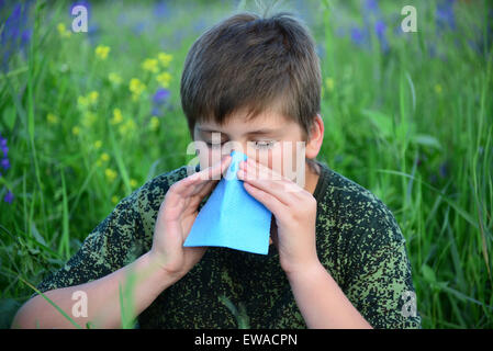 teen boy with allergies in flowering herbs Stock Photo