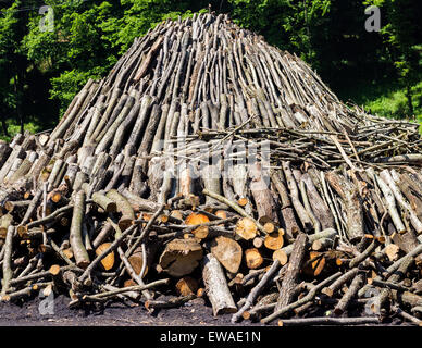 Chopped up wood in a large, pyramid shaped pile used by traditional coal-burners in Romania. Stock Photo
