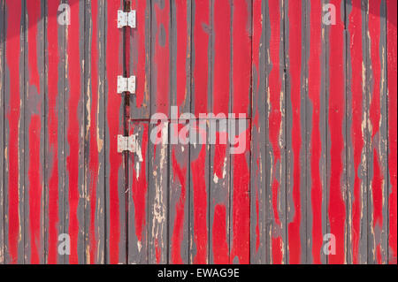 Bright red scarlet ridges on ridges galvanized metal door hidden by lines rustic corrugated metal steel iron entrance Stock Photo
