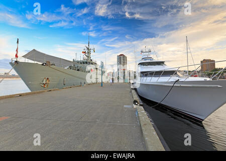 HMCS Nanaimo tied up beside luxury yacht at marina, Nanaimo, British Columbia Stock Photo