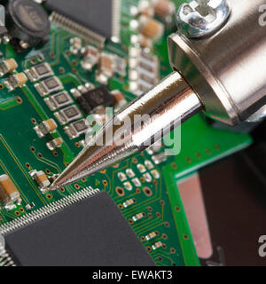 Soldering iron with microcircuit - closeup studio shot Stock Photo