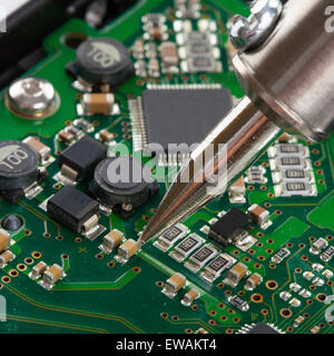 Studio shot of soldering iron with microcircuit Stock Photo