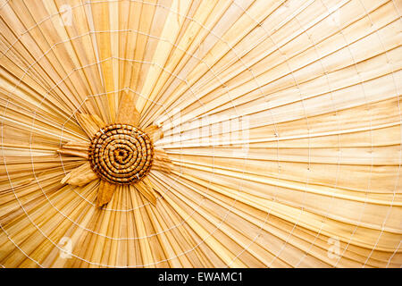 The Inside of a Asian straw paddy hat, also called a coolie hat, close up of the pattern and apex of the conical rose, center piece. Stock Photo