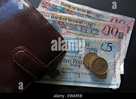 Northern Irish £5, £10 notes and pound coins, legal tender from the Bank Of Ireland  Belfast, next a wallet Stock Photo
