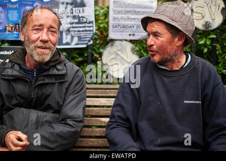Two homeless men sitting on a bench Stock Photo